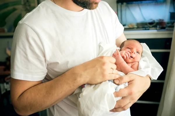Ojciec trzyma nago noworodka syna w dłoniach w białym pieluchy — Zdjęcie stockowe