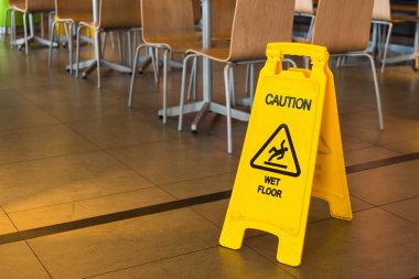 Yellow sign that alerts for wet floor in the restaurant.Thailand clipart
