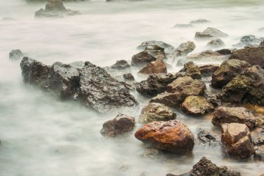 Köpüklü dalgalar Tayland bir kayalık sahil karşı sabah zamanında sıçramasına ile uzun pozlama deniz manzarası