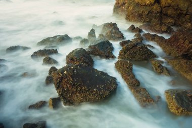 Köpüklü dalgalar Tayland bir kayalık sahil karşı sabah zamanında sıçramasına ile uzun pozlama deniz manzarası
