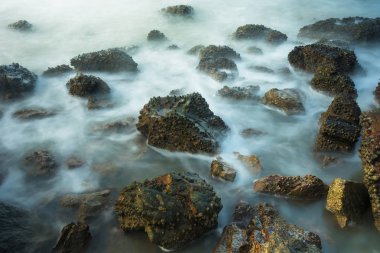 Köpüklü dalgalar Tayland bir kayalık sahil karşı sabah zamanında sıçramasına ile uzun pozlama deniz manzarası