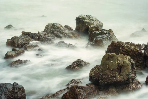 长的暴露海景与泡沫波浪飞溅对泰国的岩石海岸在早晨时间 — 图库照片