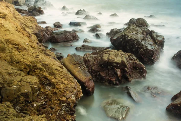 Lange Blootstelling Zeegezicht Met Schuimende Golven Spatten Tegen Een Rotsachtige — Stockfoto