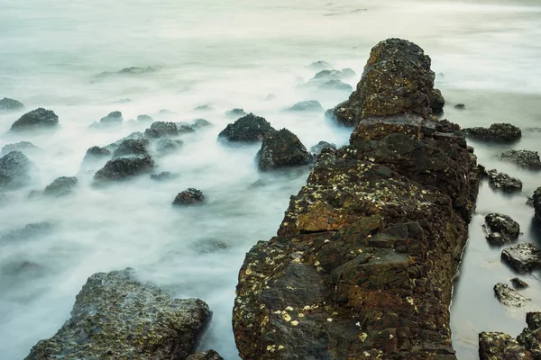 Lange Blootstelling Zeegezicht Met Schuimende Golven Spatten Tegen Een Rotsachtige — Stockfoto