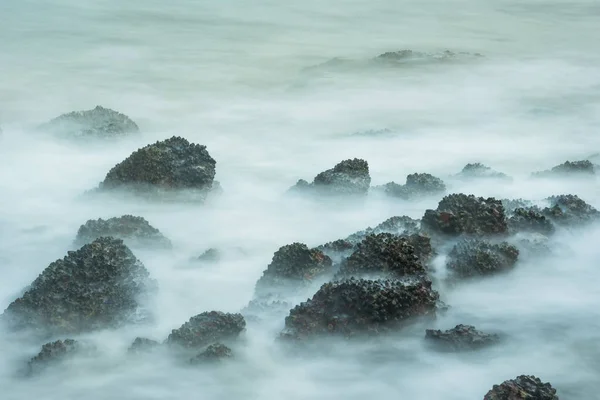 Lange Blootstelling Zeegezicht Met Schuimende Golven Spatten Tegen Een Rotsachtige — Stockfoto