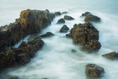 Köpüklü dalgalar Tayland bir kayalık sahil karşı sabah zamanında sıçramasına ile uzun pozlama deniz manzarası