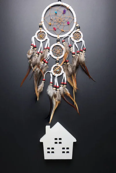 Dream catcher with feathers threads and beads rope hanging spiritual folk american native indian amulet and white home isolated on black background.Concept prevent evil in Halloween