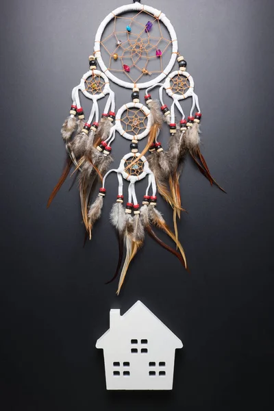 Dream catcher with feathers threads and beads rope hanging spiritual folk american native indian amulet and white home isolated on black background.Concept prevent evil in Halloween