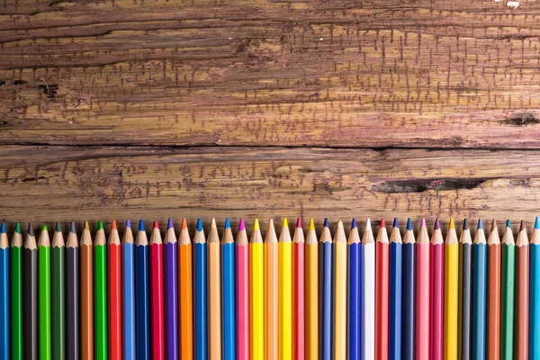 在木质背景上的一组彩色铅笔的顶部视图 带您留言的空间 — 图库照片