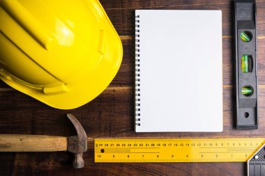 Boş defter Teknik İnceleme ve İnşaat araçları kopya alanı ile ahşap arka plan üzerinde. Emlak kavramı, yeni ev kavramı, finans kredi iş kavramı, tamir bakım kavramı