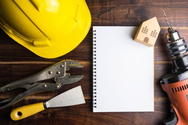 Boş defter Teknik İnceleme ve İnşaat araçları kopya alanı ile ahşap arka plan üzerinde. Emlak kavramı, yeni ev kavramı, finans kredi iş kavramı, tamir bakım kavramı
