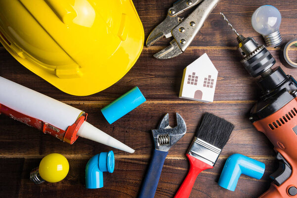 Бумажная игрушка для белого дома и строительные инструменты на деревянном фоне с пространством для копирования.
.