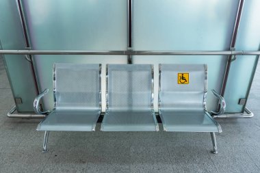 Paslanmaz çelik sandalye engelliler için tren hizmetleri kullanımını kolaylaştırmak için Engelli tabela ile tren istasyonunda. Tayland