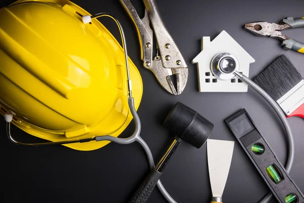 House model with stethoscope and construction tools on black background with copy space.Real estate concept, Repair maintenance concept isolated on black background.Indicates the health of the house