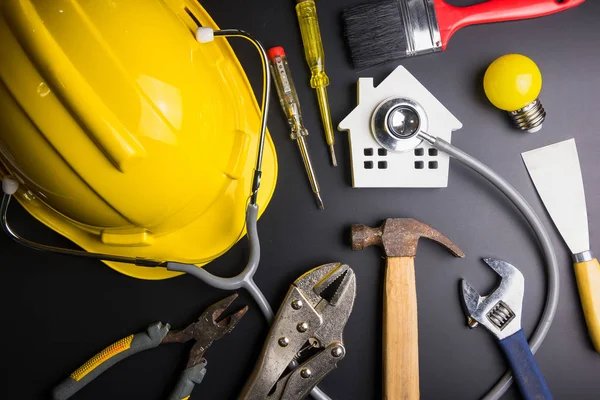 House model with stethoscope and construction tools on black background with copy space.Real estate concept, Repair maintenance concept isolated on black background.Indicates the health of the house