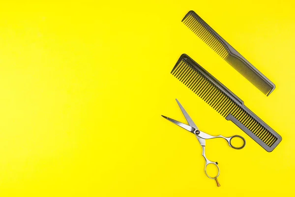 Stilvolle professionelle Friseurschere und Kamm auf gelbem Hintergrund — Stockfoto