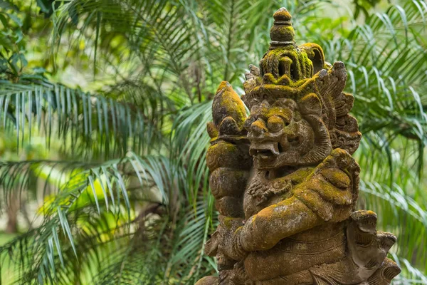 Balinesischen geschnitzten Stein Statue von rakasa mit grünem Moos bedeckt. — Stockfoto