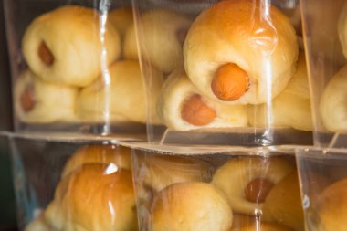 Fırındükkanında plastik poşet içinde sosisli ekmek. Tayland.