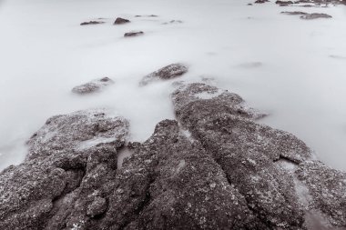 Fotoğraf Siyah ve Beyaz Uzun Pozlama Fotoğraf Dalgalar üzerinde taş