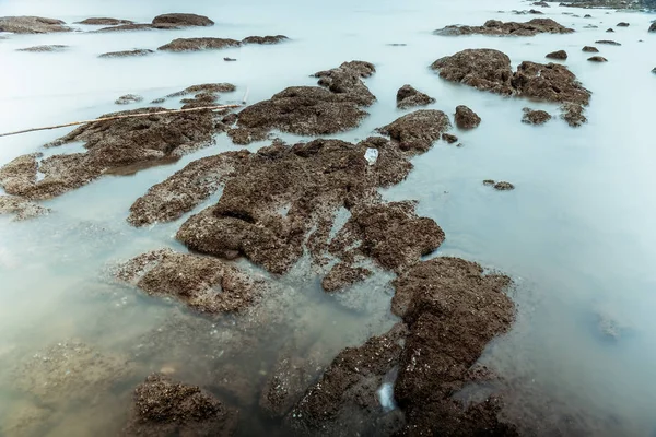 Μακρά έκθεση φωτογραφίας των κυμάτων σε πέτρινα νερά της παραλίας Edge AB — Φωτογραφία Αρχείου