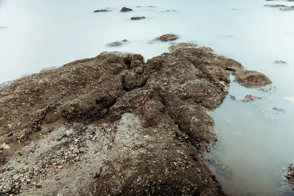 石滩水域边缘波浪的长曝光摄影 — 图库照片