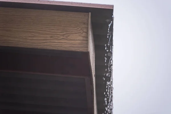 金属板屋根の雨嵐、雨水が屋根を流れ落ちる. — ストック写真