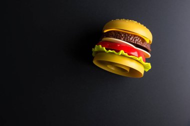 Siyah arka plan üzerinde Plastik burger Fast food. Çocuk oyuncakları. Co