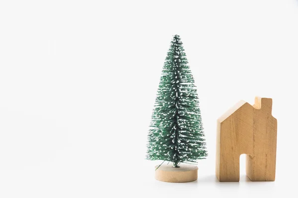 Pequeño árbol de Navidad y juguete de casa de madera aislado en respaldo blanco — Foto de Stock