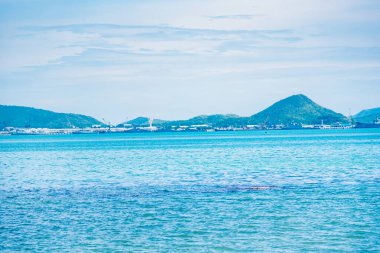 Tekne ve dağ manzaralı deniz manzarası görünümünde güneşli bir gün.
