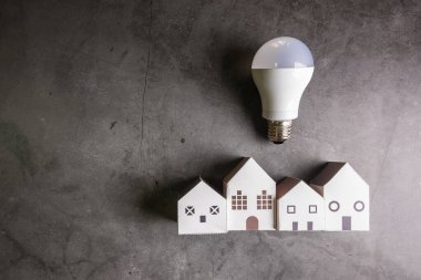 House and light bulbs on stone pattern background with copy spac