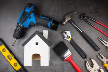 Tahta model beyaz evler ve çimento gri arka planda Ev Tamiri El Aletleri. Konsept ev onarımı, ev tamiri, evi yenileme.