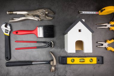 Tahta model beyaz evler ve çimento gri arka planda Ev Tamiri El Aletleri. Konsept ev onarımı, ev tamiri, evi yenileme.