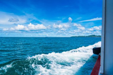 Su mavisi okyanus su sıçratır ve deniz yolunda tekne, dalgalar geminin kenarına vurur.
