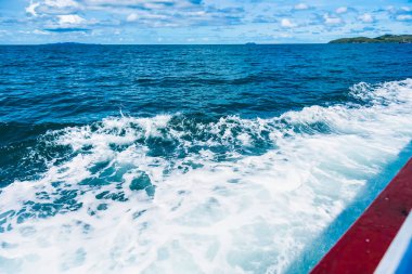 Su mavisi okyanus su sıçratır ve deniz yolunda tekne, dalgalar geminin kenarına vurur.