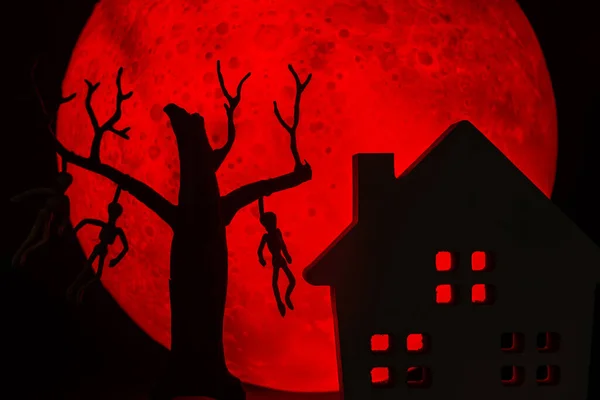 男と死んだ立っている木のシルエットは 骨やホラーお化け屋敷に死者を絞首刑にしました 背景に赤い満月があります ハロウィンホラーのコンセプト — ストック写真