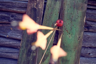 Old wooden fence with an apple in the form of a target and arrows from a bow. clipart