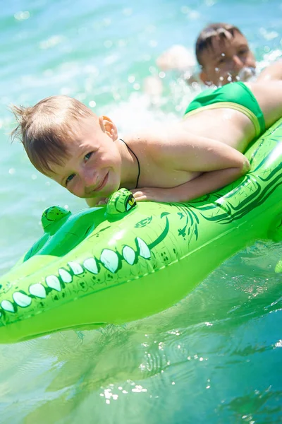 Older Brother Teenager Rolls Younger Brother Sea Toy Inflatable Crocodile — Stock Photo, Image