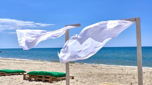 Вітер дме білі штори на навіс, на березі моря — стокове фото