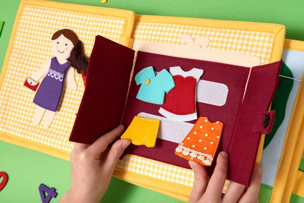 Children 'S textil-képzés. Lány játszik egy báb-ruhák fel a ruhák — Stock Fotó