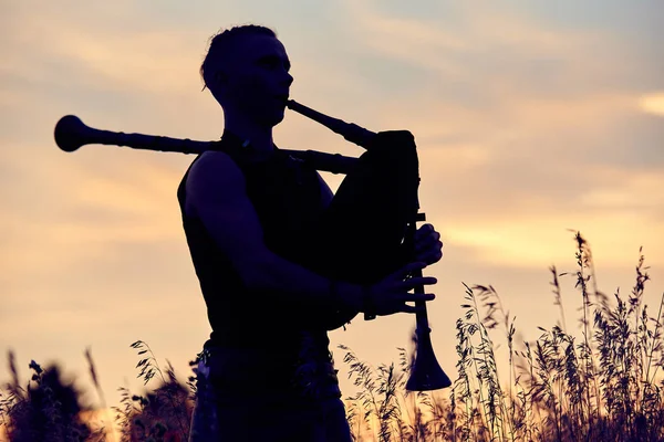 Młody Współczesny Człowiek Odgrywa Muzyczne Dudy Zewnątrz Siluet — Zdjęcie stockowe