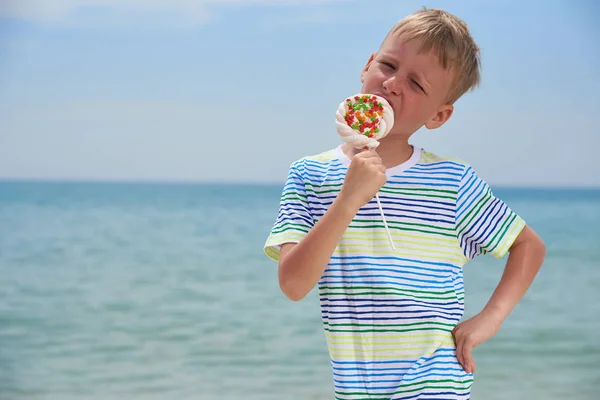 PEQUEÑO NIÑO COMIENDO EN LA PLAYA SWEET CANDY — Foto de Stock