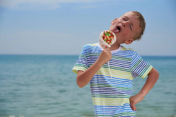 Piccolo ragazzo che mangia sulla spiaggia dolcissima dolcezza — Foto Stock