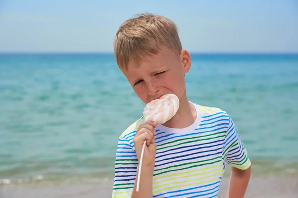 Piccolo ragazzo che mangia sulla spiaggia dolcissima dolcezza — Foto Stock