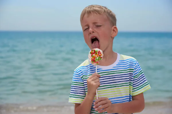 Piccolo ragazzo che mangia sulla spiaggia dolcissima dolcezza — Foto Stock