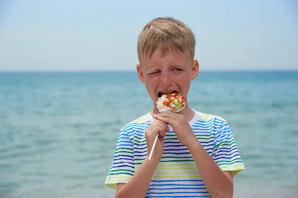 Piccolo ragazzo che mangia sulla spiaggia dolcissima dolcezza — Foto Stock