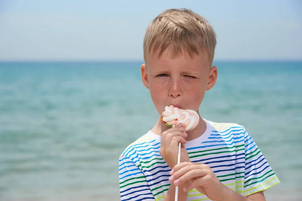 Piccolo ragazzo che mangia sulla spiaggia dolcissima dolcezza — Foto Stock