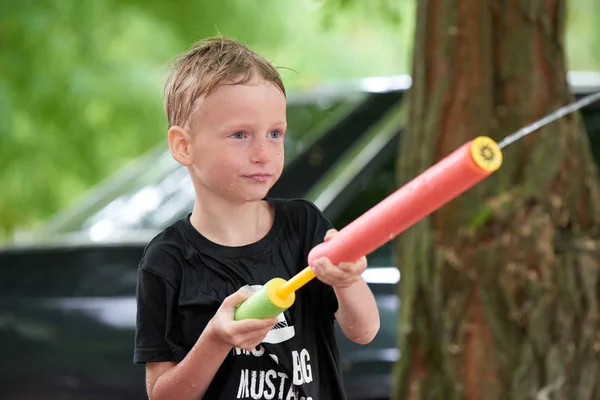 Kinder spielen. Junge plätschert vor sich hin — Stockfoto