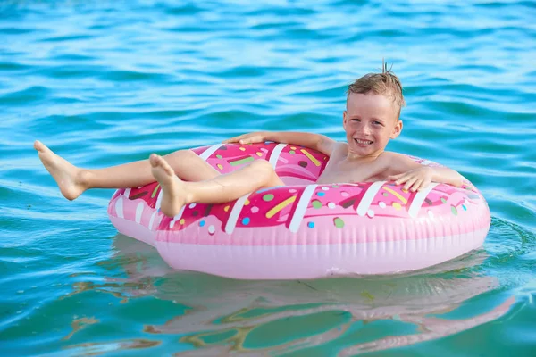 EL NIÑO 7 AÑOS FLOTA POR MAR EN EL CÍRCULO INFLATABLE — Foto de Stock