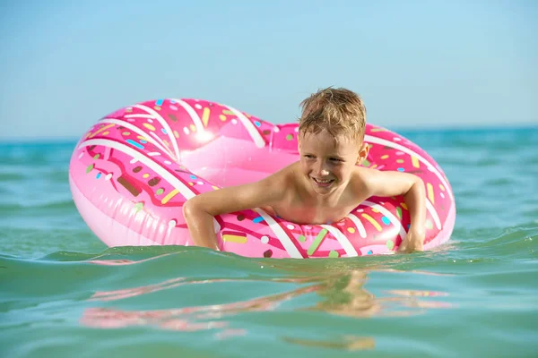 THE BOY 7 YEARS FLOATS BY SEA ON THE INFLATABLE CIRCLE — Stock Photo, Image