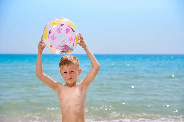 바다 근처 해변에서 풍선 공을 가진 어린 소년 7 세 — 스톡 사진